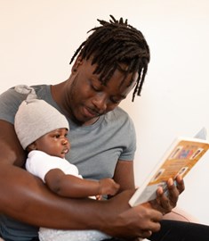 Man reading to small baby